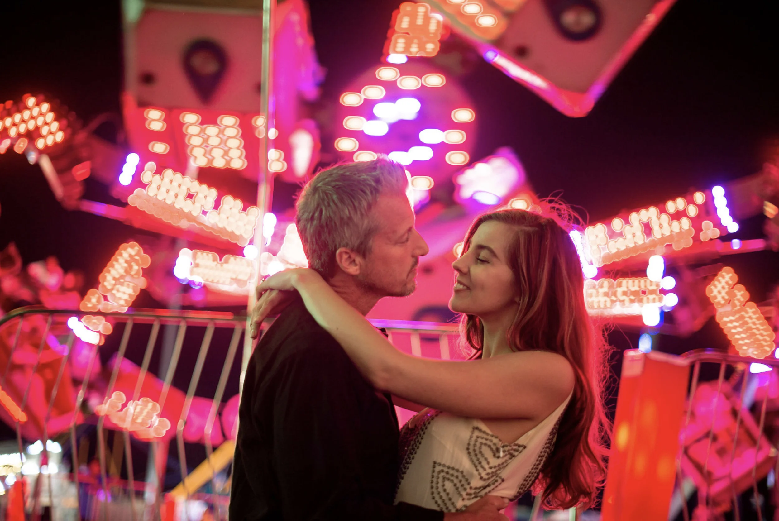 Zach Murphy of ZAM Photo (@zam.photo) shoot "A Night at the fair" with CD Geena Matuson (@geenamatuson) features neon lights in a carnival setting at the New York State Fair, with couple Jake Roberts and Molly Naef. See more @ zamphoto.net.