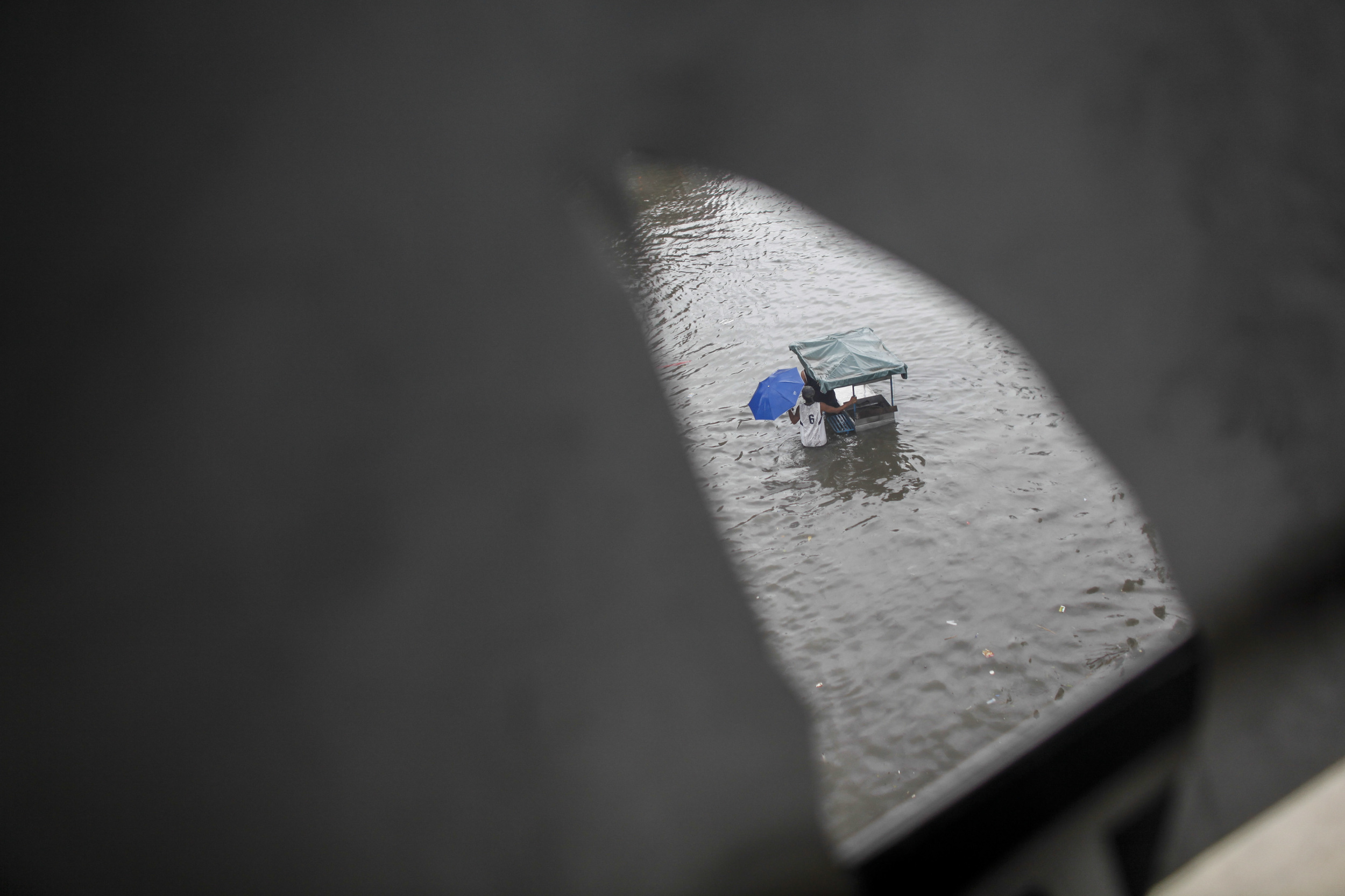  A vendor wades through floodwaters caused by monsoon rains in Sucat, Paranaque south of Metro Manila August 19, 2013. Heavy rain in the Philippine capital forced the closure of government offices, schools, banks and most private companies on Monday,
