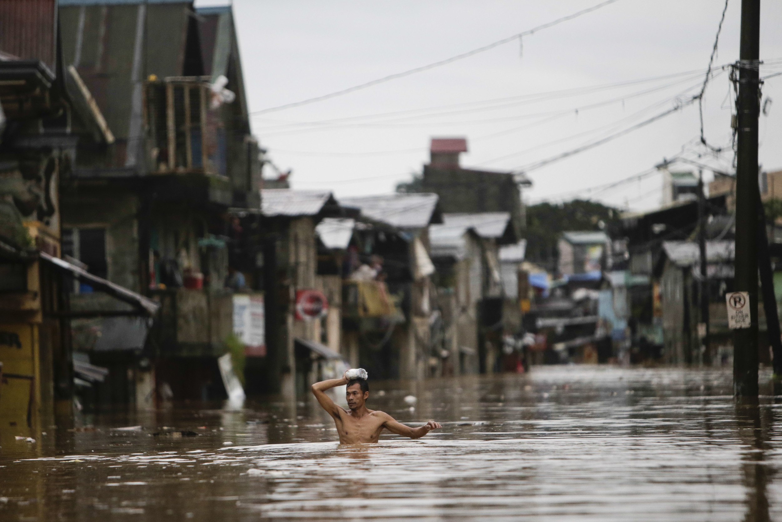  A man wades through floodwaters in Tumana, Rizal Province August 20, 2013. Monsoon rains reinforced by a tropical storm flooded half the Philippine capital in just 24 hours, triggering landslides and killing at least seven people, officials said on 