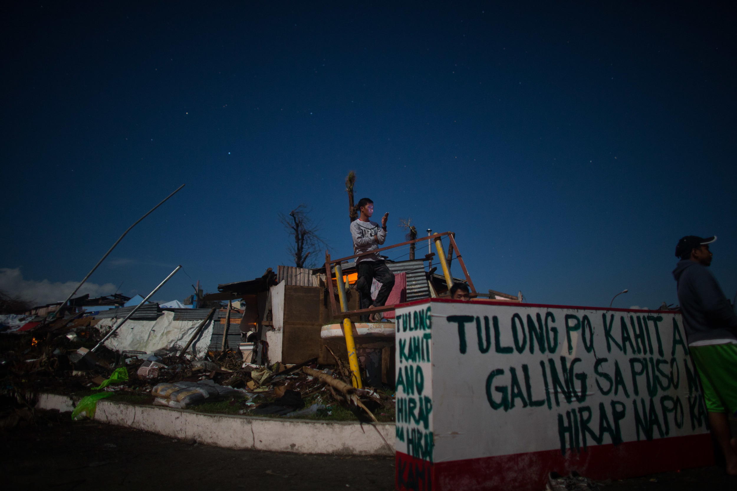  A survivor is seen at a lone spot with cellular reception in Tanauan, Leyte     