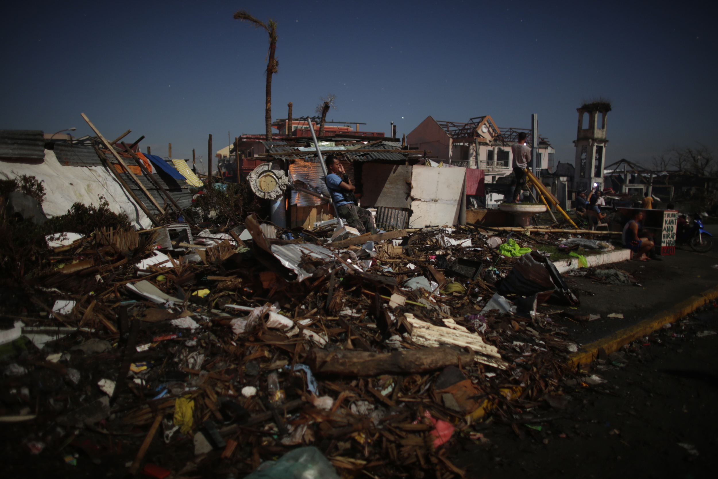  A survivor makes a phone call at the lone spot where there was mobile phone reception     