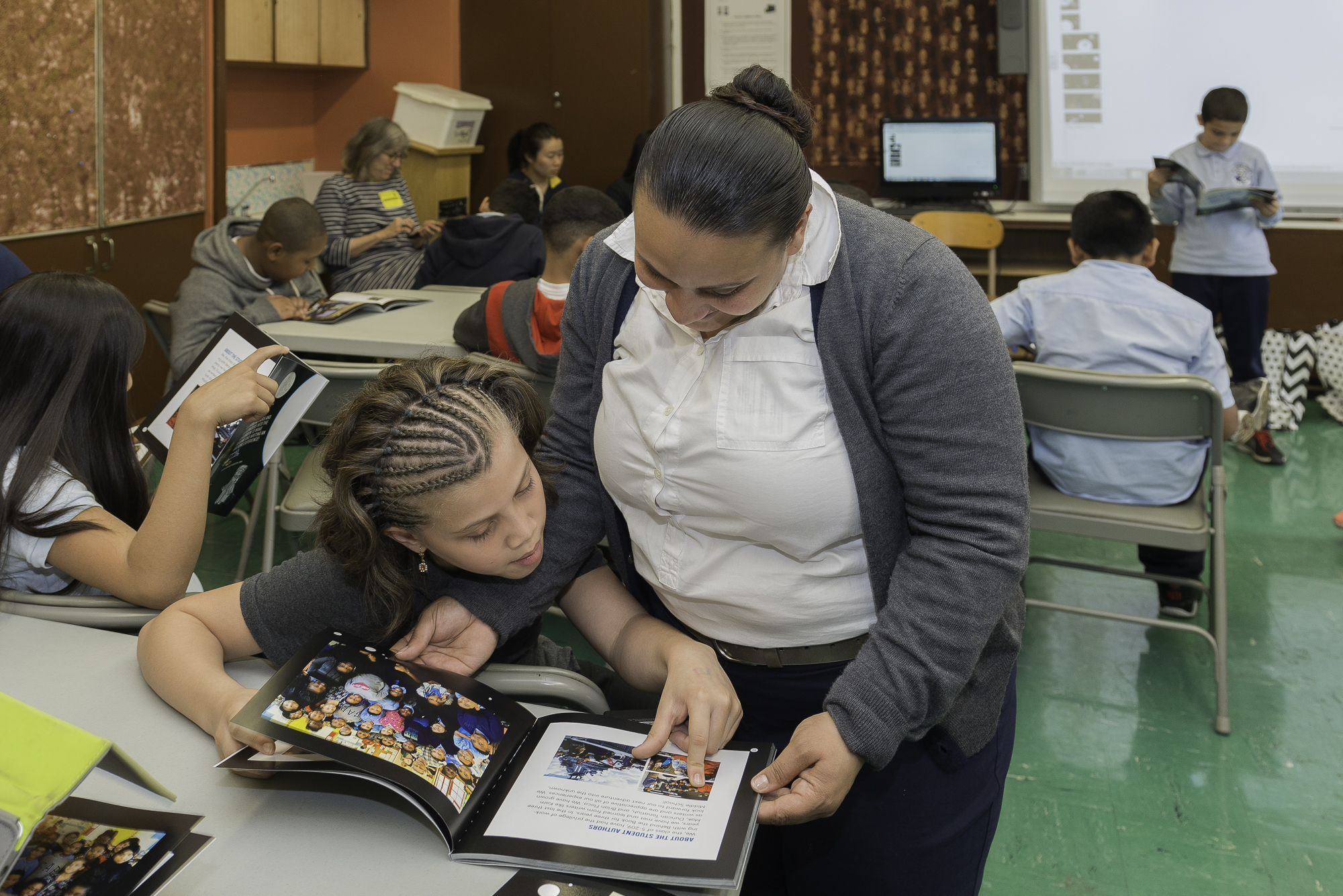 This young girl proudly shows her mother the book she helped create with the help of Behind the Book.