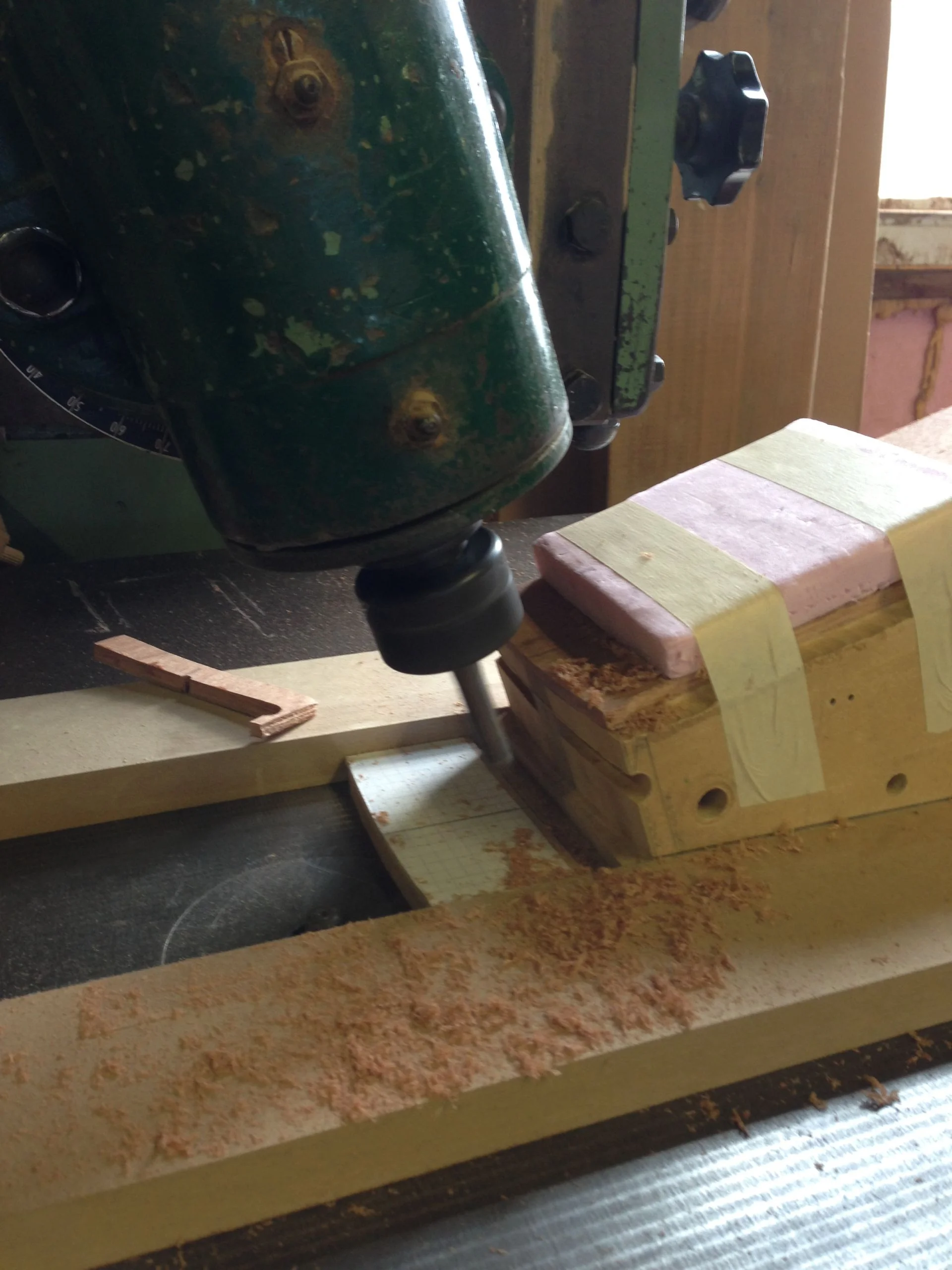   The splat is secured in a jig held square to the cutter and the pin in the router traces the desired shape.     