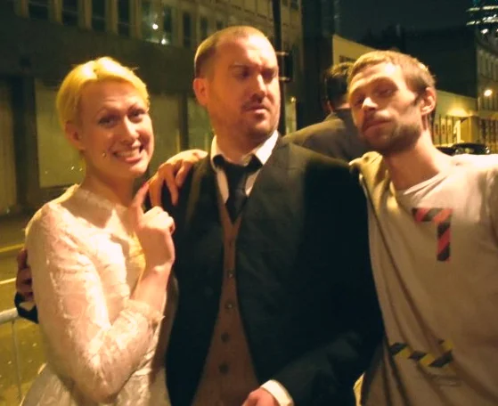 Ulysses Black and Sarah X. Delmonte, employed to impersonate newly weds on the door of a huge wedding reception in London allowing the actual wedding couple (groom featured right) to mingle at their leisure. 2009(ish)