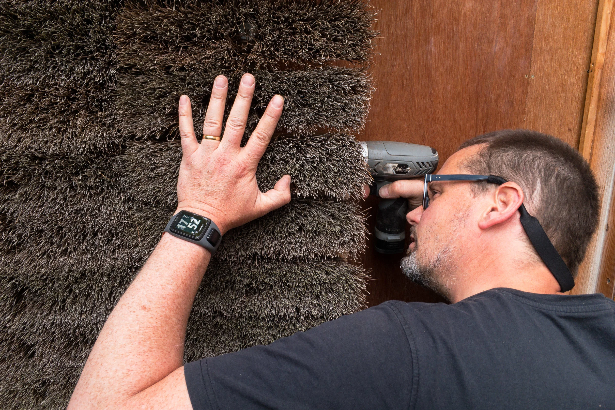 Mission Control: Tom Hughes adjusting a broom head on the facade