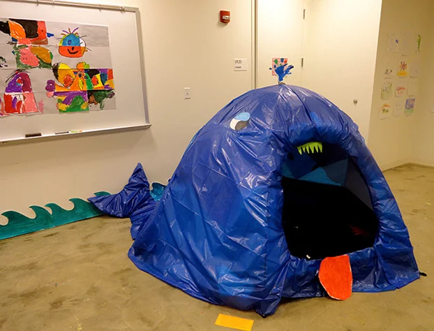 A tent transformed into an open-mouthed whale during the "Belly of a Whale" ART BRAINS project at Artisphere. The students filled the whale's belly with cut-out drawings of objects and creatures they imagined the whale had swallowed. Click here to read more about this project.