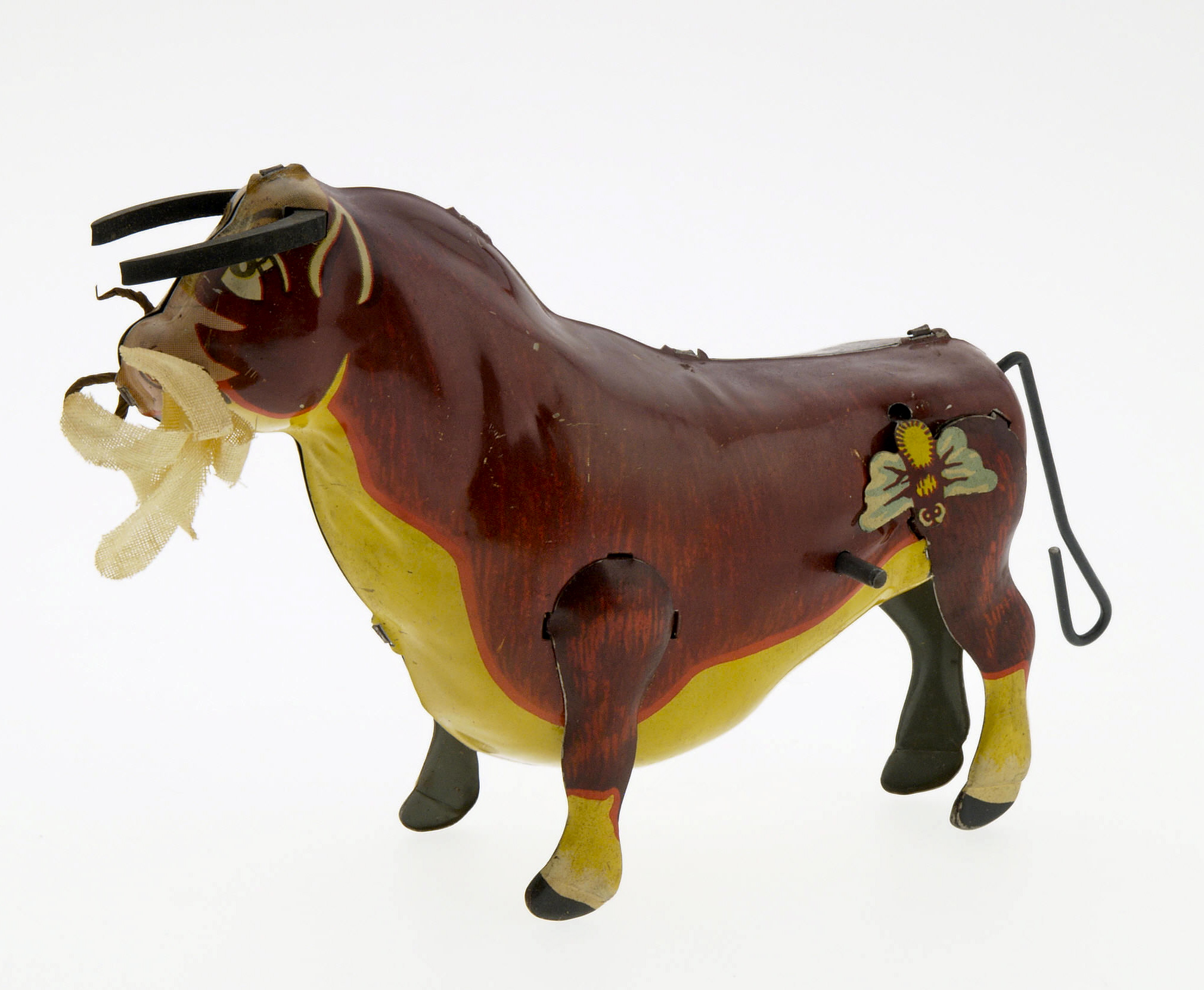 Ferdinand the Bull Wind Up with Box (Louis Marx & Co., 1938). Nice image of Ferdinand, includes rubber horns and a flower in his mouth that are often missing. This is a very difficult to find toy with its original box. Toy measures 7" x 3", box measures 3.25" x 5" x 6". Box and toy are both in Excellent to Near Mint. From the Larry Jacobs Collection.