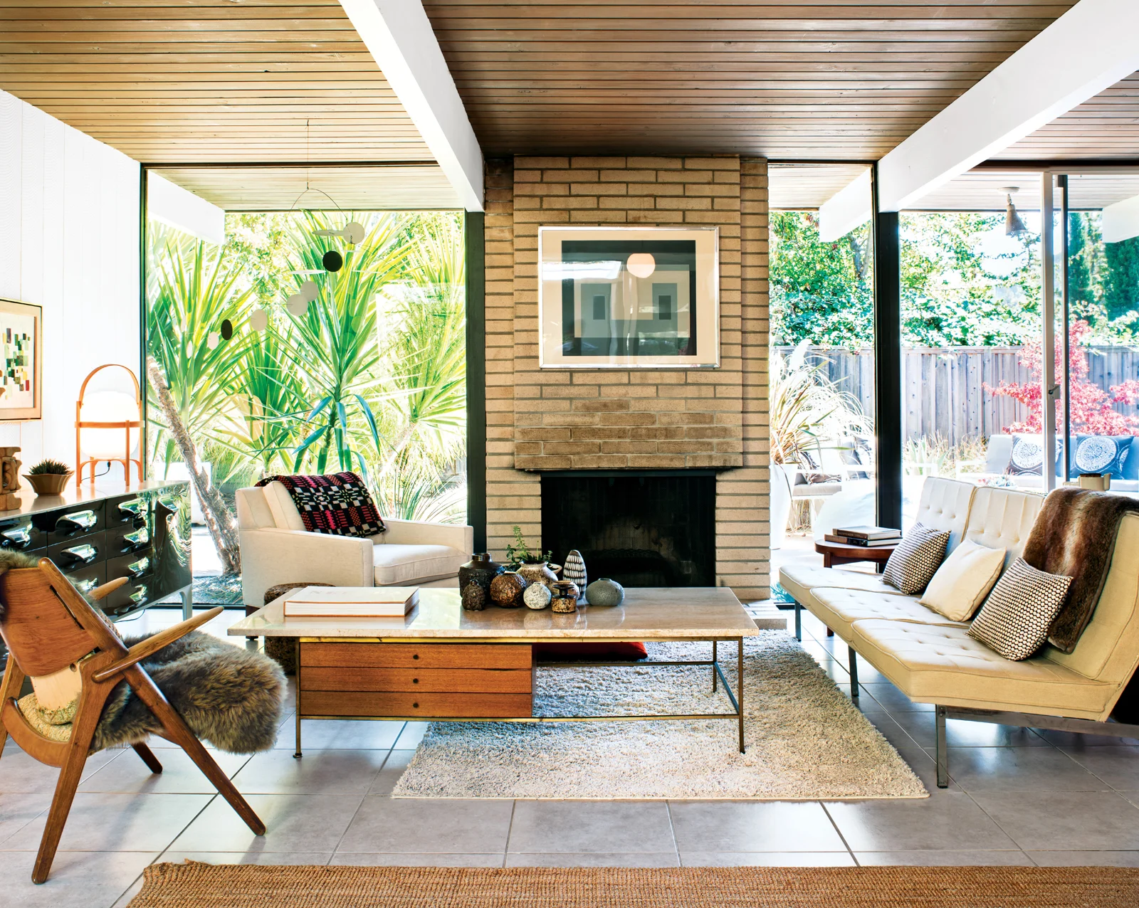 In the living room , a travertine-topped coffee table by Paul McCobb pairs well with the Florence Knoll Parallel Bar System sofa. The Josef Albers print over the fireplace is an original, scored on eBay. Photo by Drew Kelly.