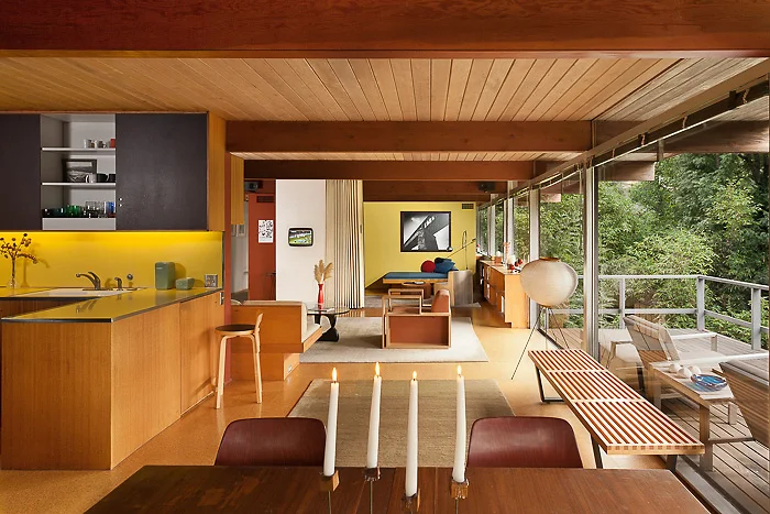 At one end of the living room, a soft wall can be pushed back to reveal the den--essentially stretching the main living space from one end of the house to the other.