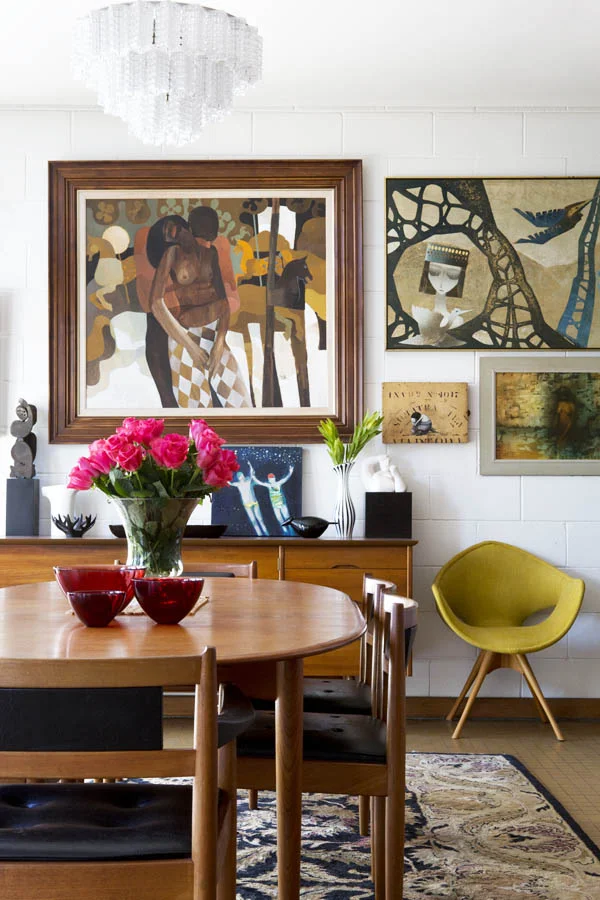 The Baxters have also chosen modern but warm danish modern pieces that match the strong design of the home. Warm woods, a splash of color, and an ART WALL!