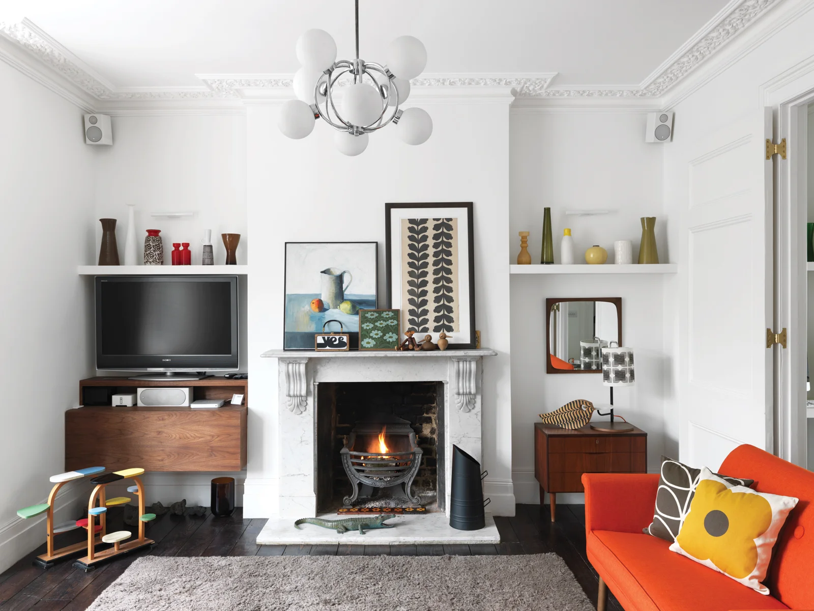 In the living room, salvaged ebony wood flooring and pops of citrus.