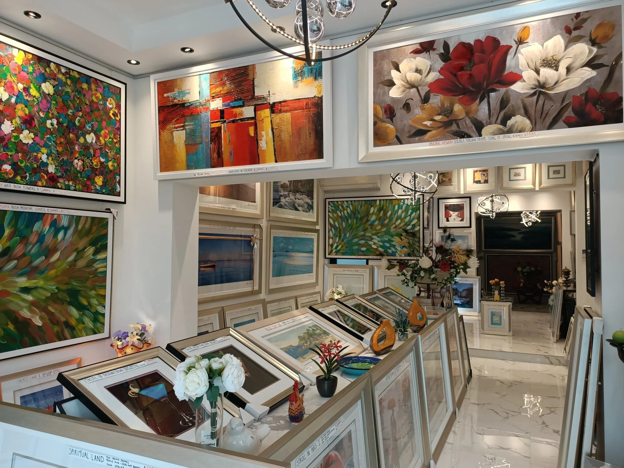 Interior view of the Art Reflection flagship gallery in Mosman featuring a wide selection of framed colorful abstract and landscape paintings.