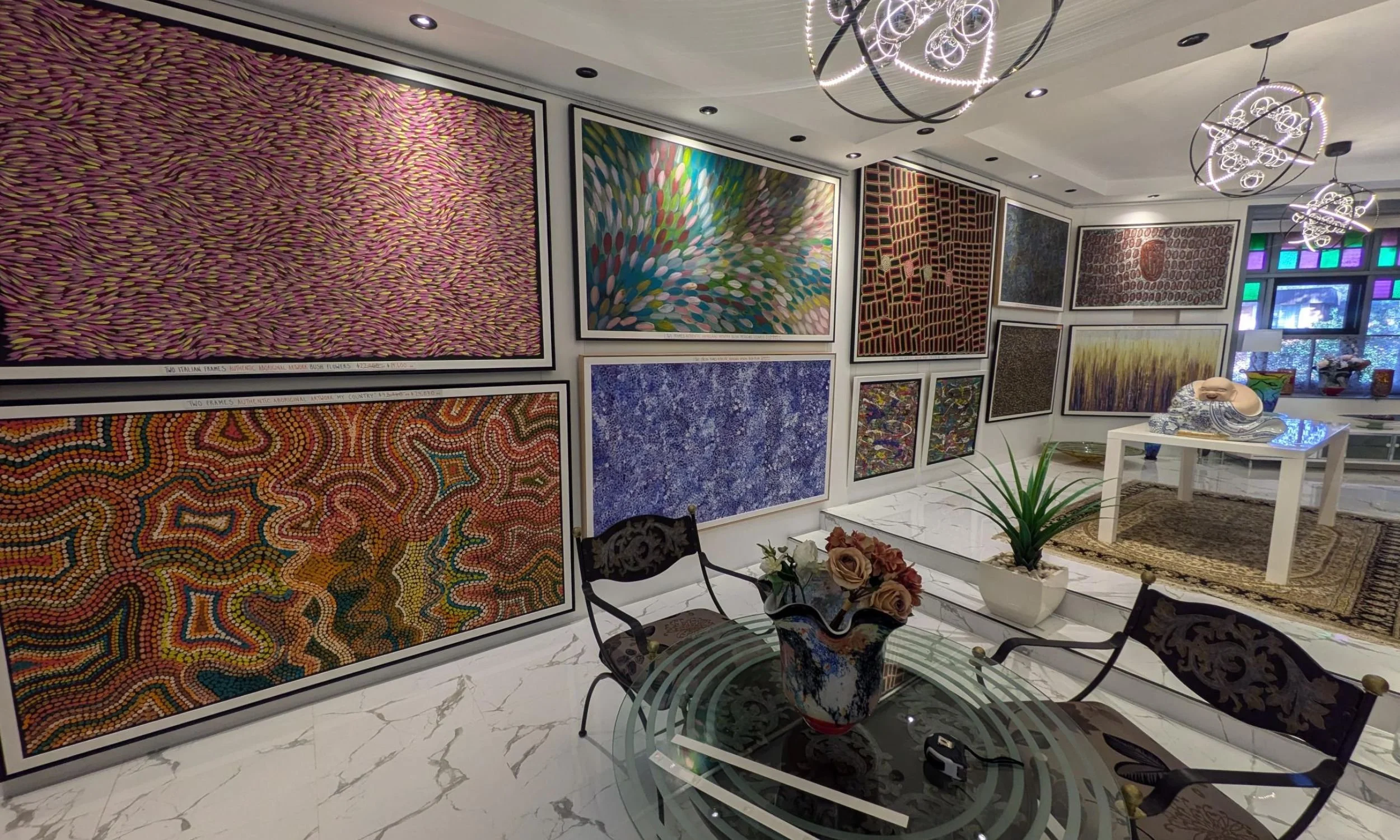 Interior view of Art Reflection gallery in Mosman featuring a large collection of framed Indigenous Australian dot paintings and fine art on display.