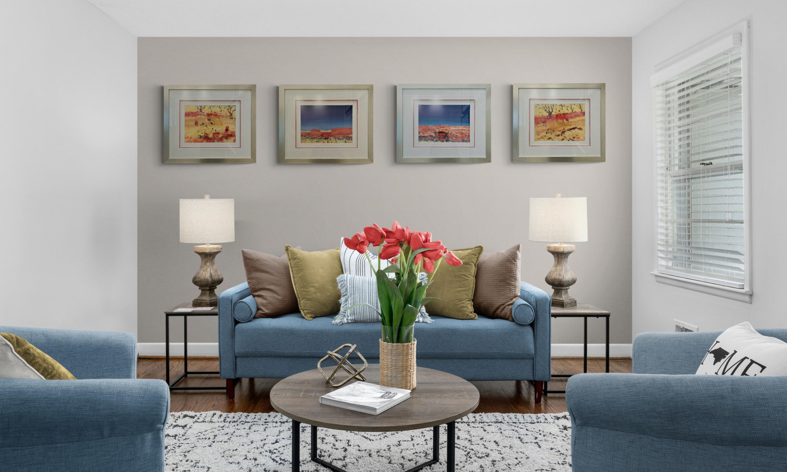 Four matching custom framed landscape art prints with silver frames and white matting displayed in a modern living room setting by Art Reflection Mosman.