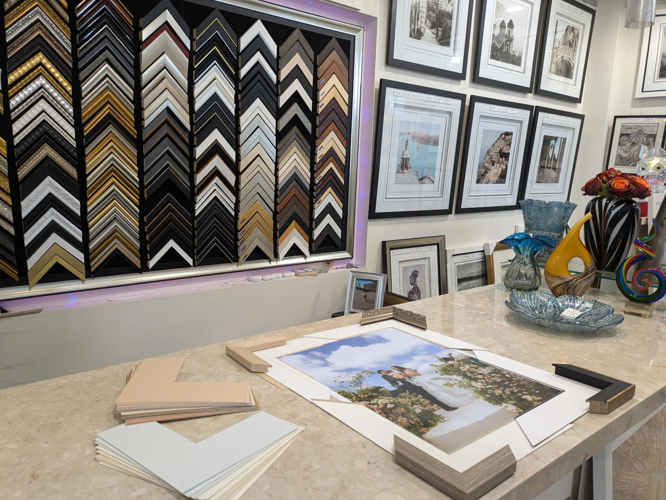 Professional custom framing consultation area inside the Art Reflection gallery in Mosman, featuring a wide selection of fine art frame samples.
