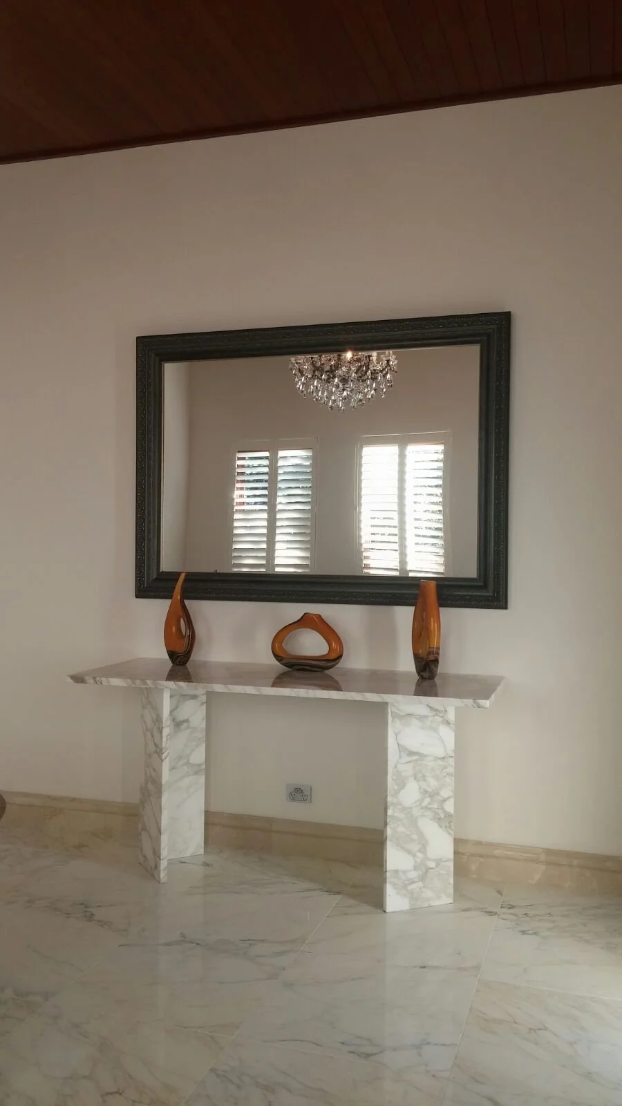 Classical ornate mirror featuring hand-finished gold leaf framing and a bevelled edge."
