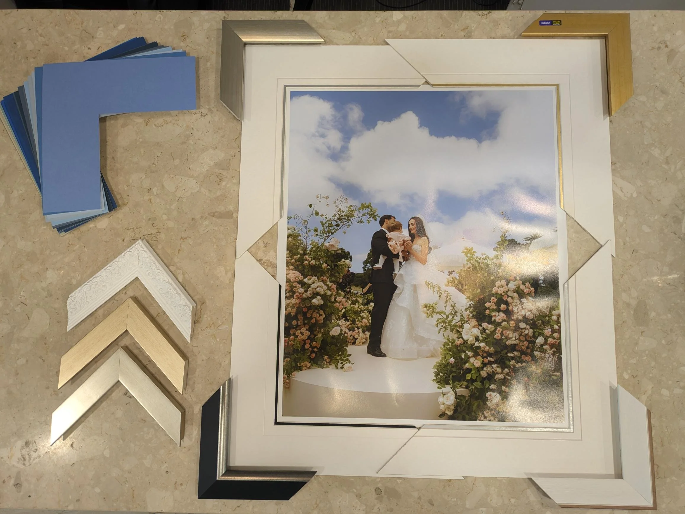 Expert custom framing consultation for a wedding photograph at Art Reflection gallery in Mosman, displaying frame profile and mat board samples.