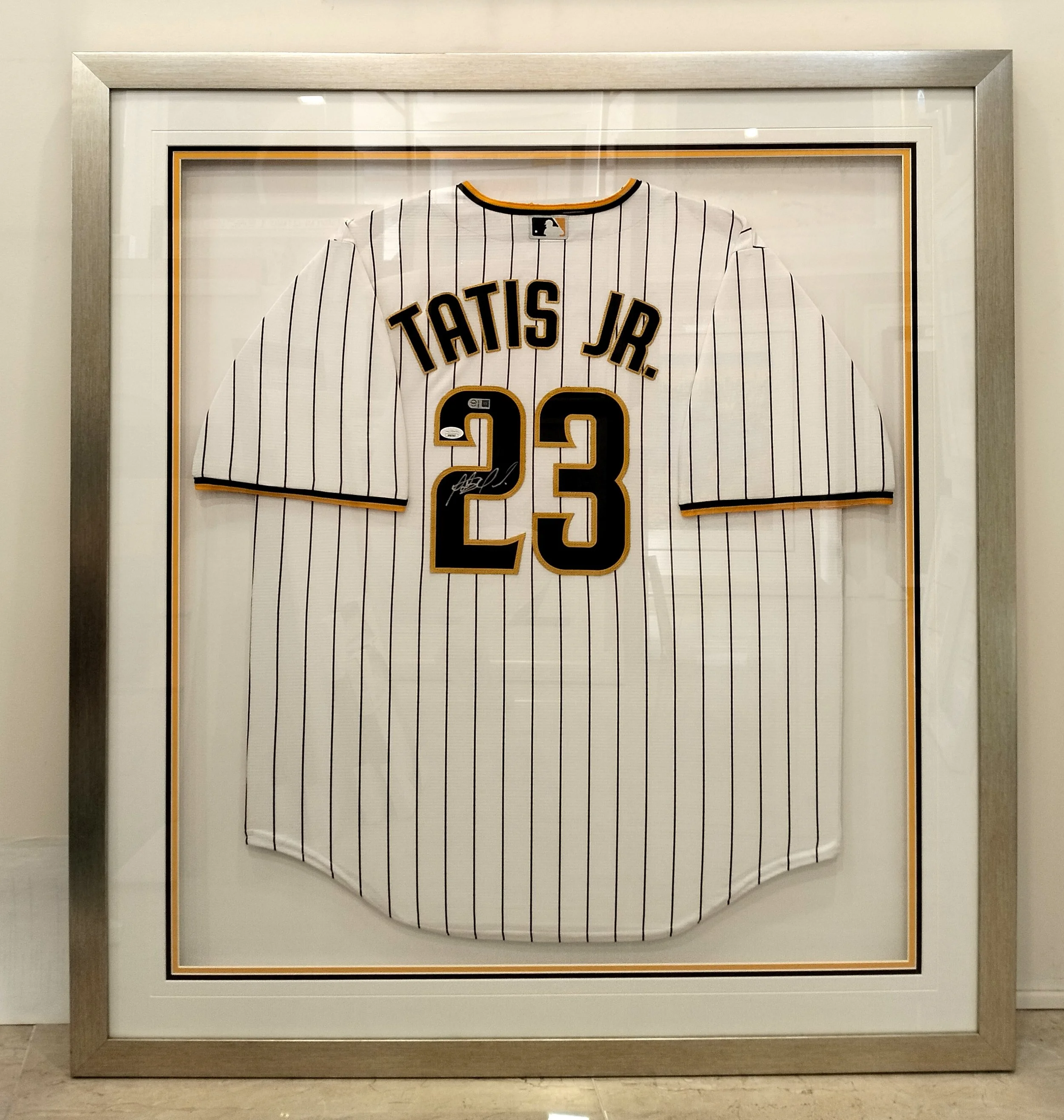 Deep shadow box frame housing sports memorabilia and 3D artifacts for preservation and display.
