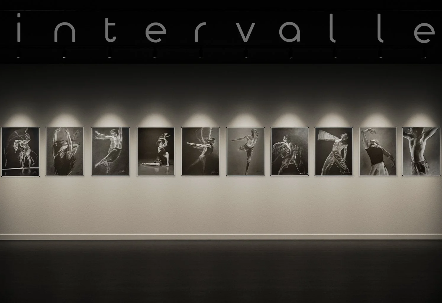 An art gallery wall displaying ten black and white photographs of dancers or performers in motion, under the word 'intervallle' illuminated at the top.