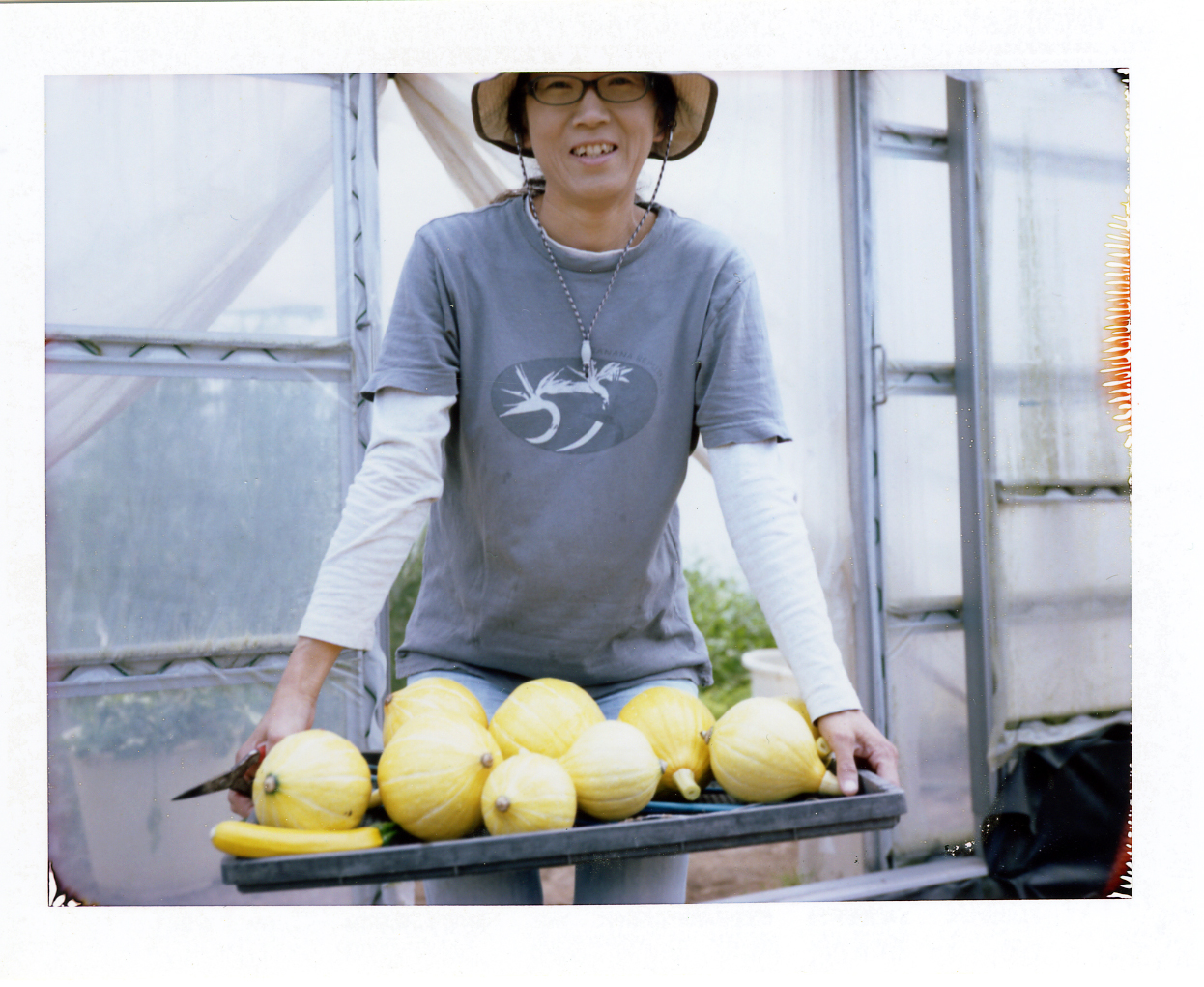 「ファーム・ベジコ」の長崎雅代さん。サラダで食べるととても美味しい自慢のコリンキーと。