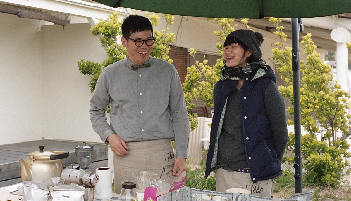 『 旅ベーグル 』 松村さん(左)、通称 マツジュン...とゆりかさん(右)。今回は、得意のベーグルと一杯一杯、丁寧にドリップしたコーヒーで参戦。美味しいベーグルはあっという間に売り切れました。 ゆりかさんは、会場のオリーブの枝や野花の装飾も担当していただきました。