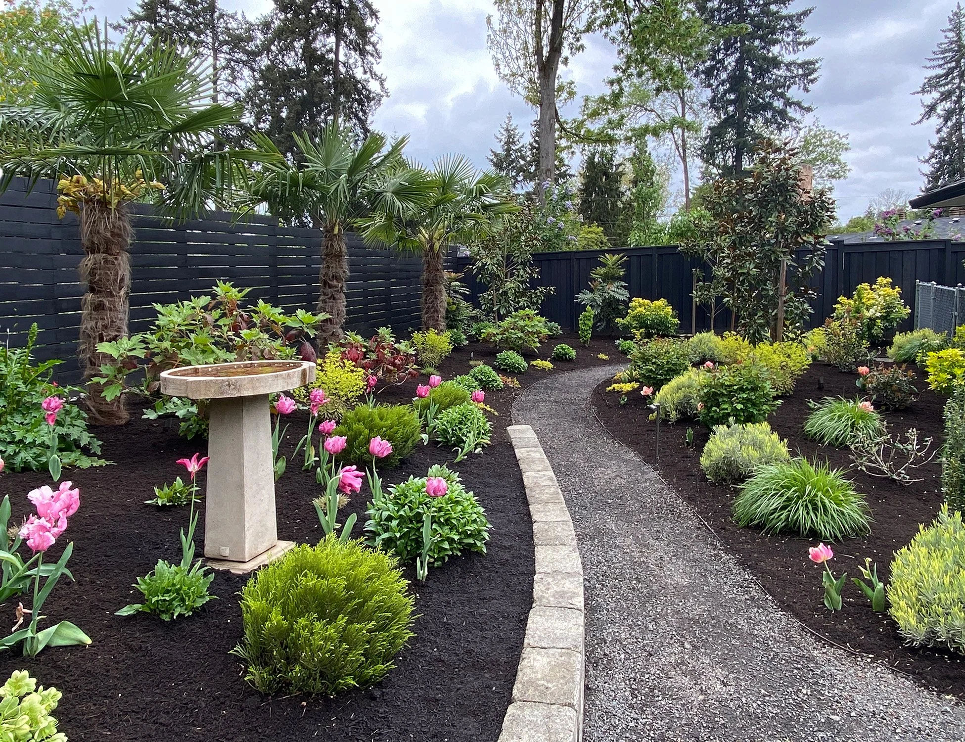 Raleigh Hills, Oregon. Traditional NW style backyard garden. We added the short retaining paver wall to gently level the slope and to add height interest.