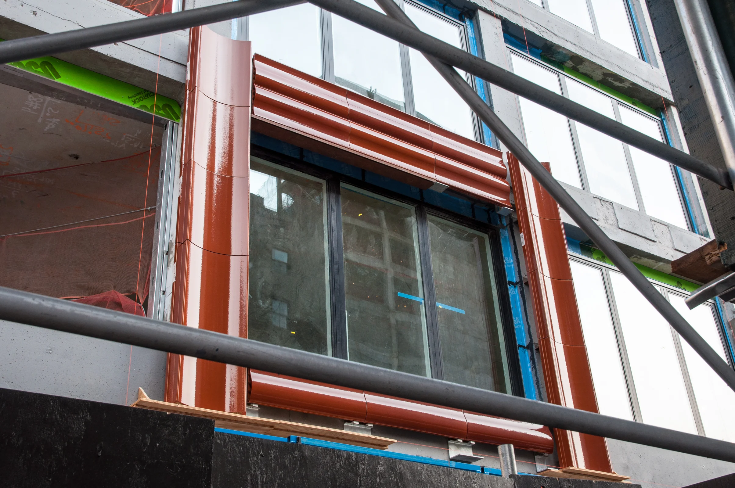 Terracotta panels installed around a second floor window.