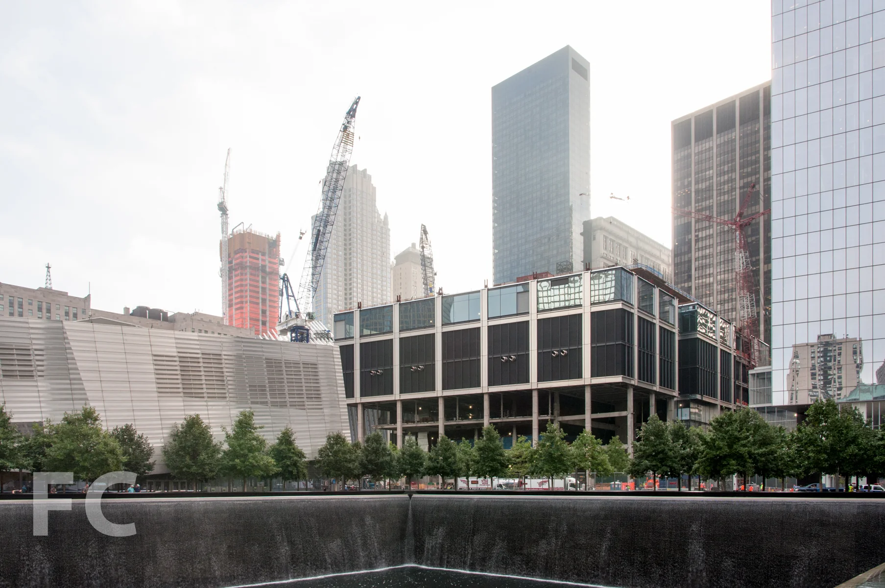 The WTC museum (left), 3 WTC (center), and 4 WTC (right) seen from the Memorial pools with 30 Park Place under construction in the background.