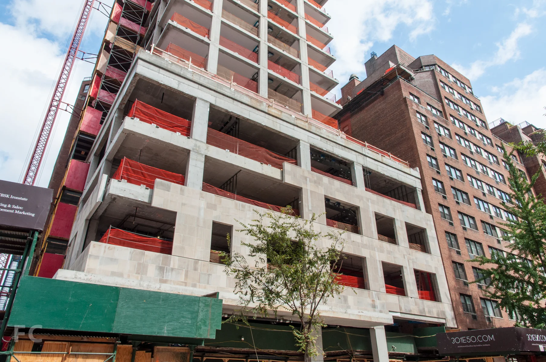 The south façade of the podium with limestone installation underway.