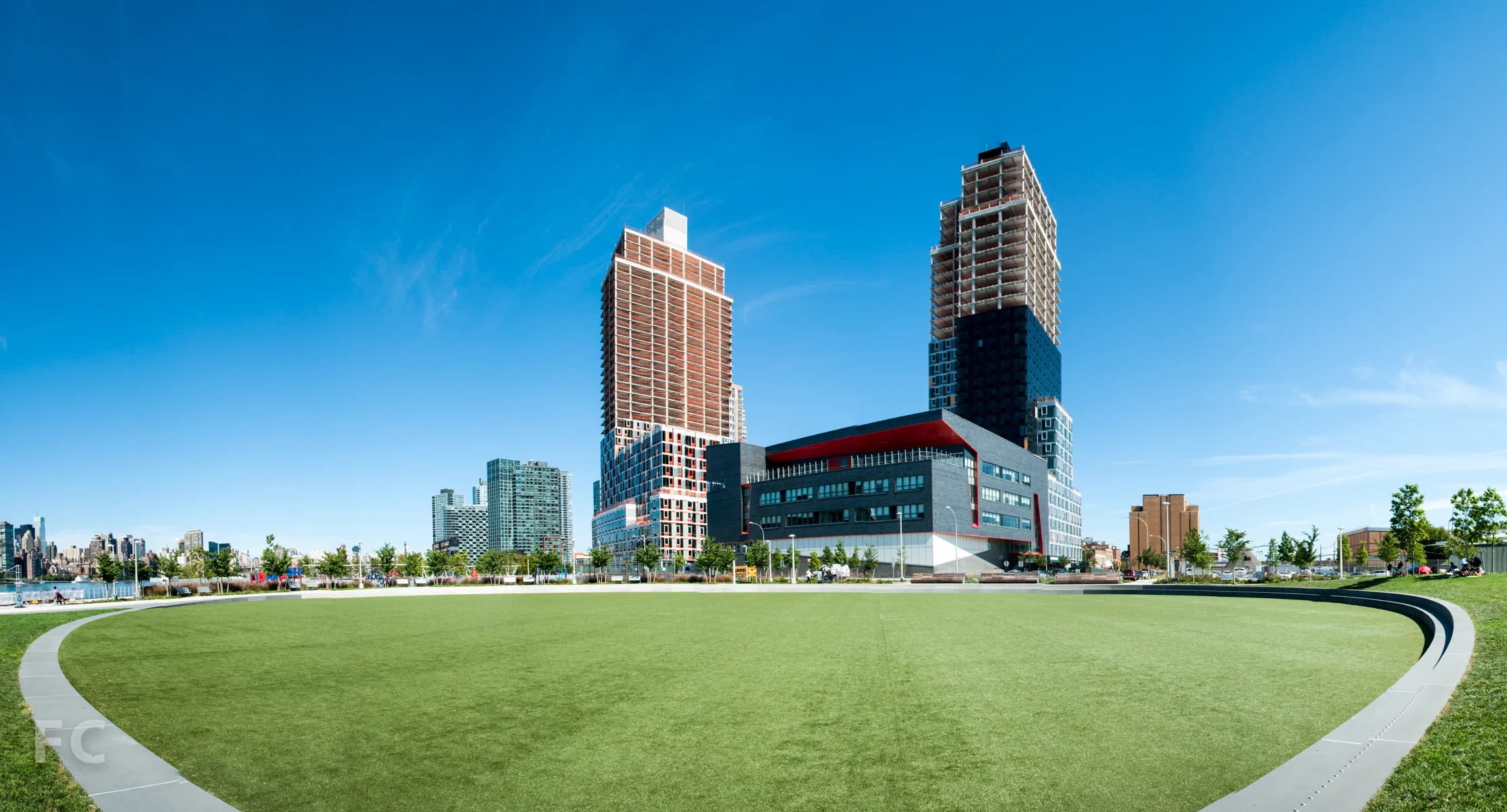 Building A (left) and Building B (right) from the oval green at Hunters Point South Park.