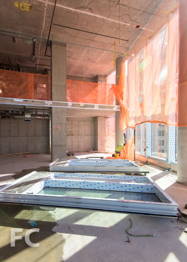 Curtain wall panels await installation in a double height living room.
