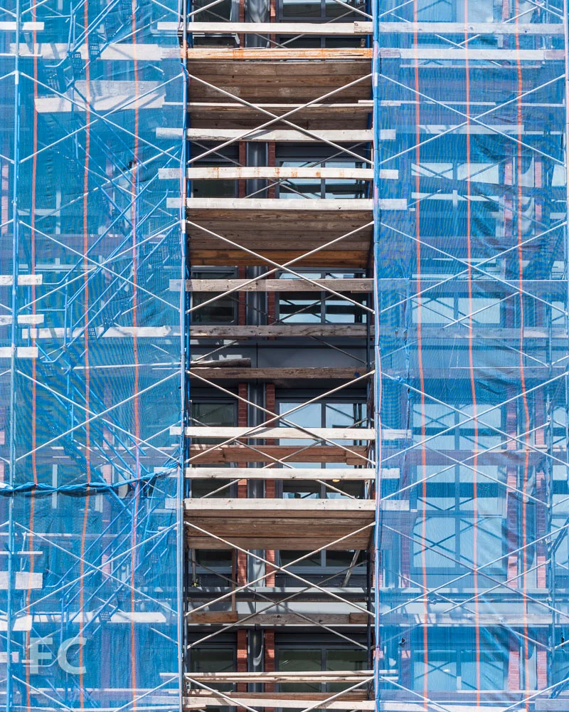 Detail of the façade of 372 Lafayette Street from behind construction scaffolding.