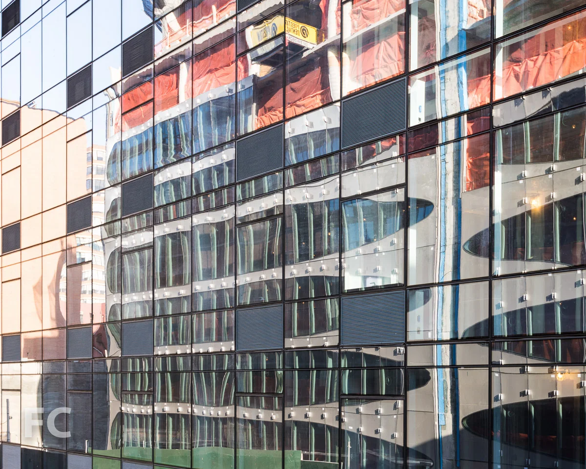 Reflection of the façade in the curtain wall of 323 Tenth Avenue.