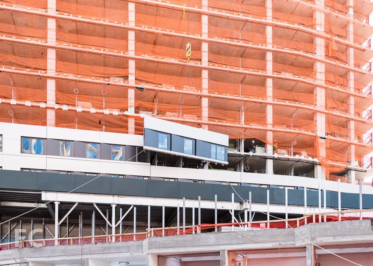 Close-up of facade panel installation underway at the Residential Building.