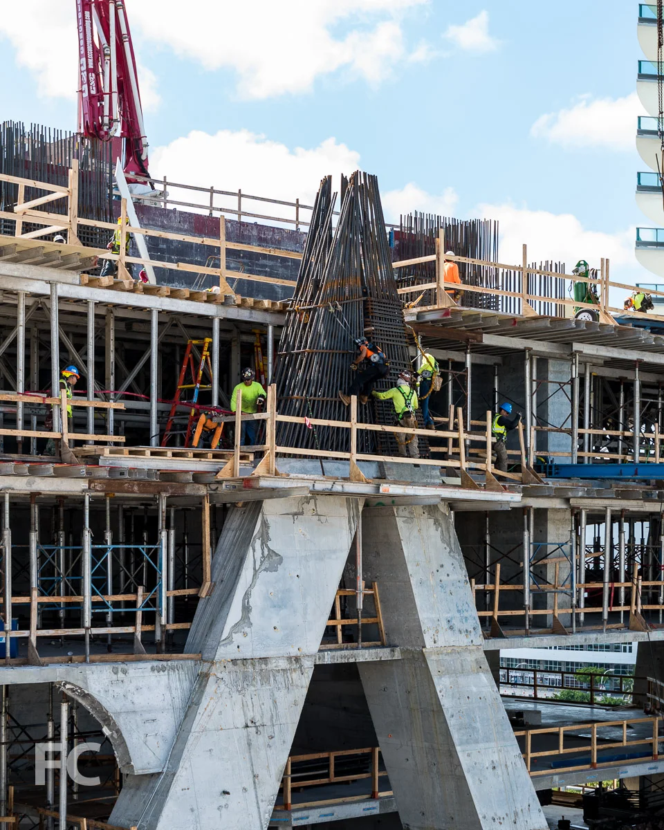 Close-up of workers preparing rebar for the concrete superstructure.