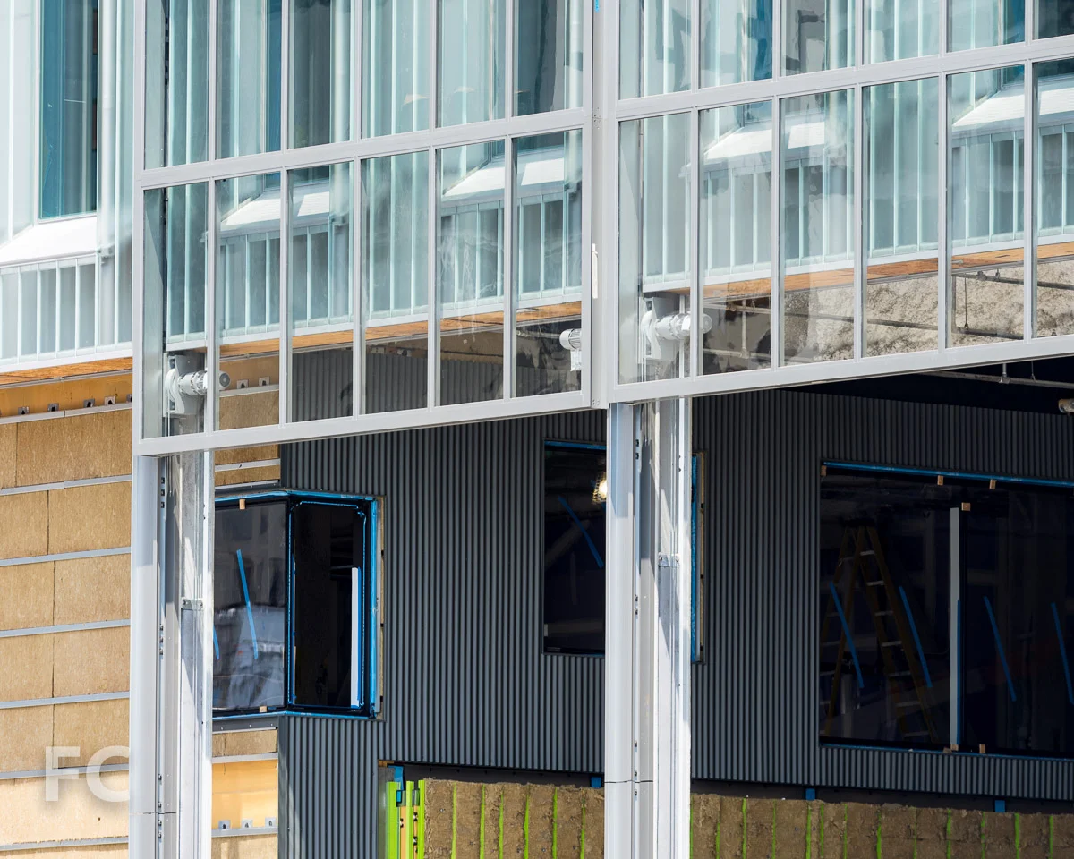 Corrugated metal panel façade installed on the lower floors.