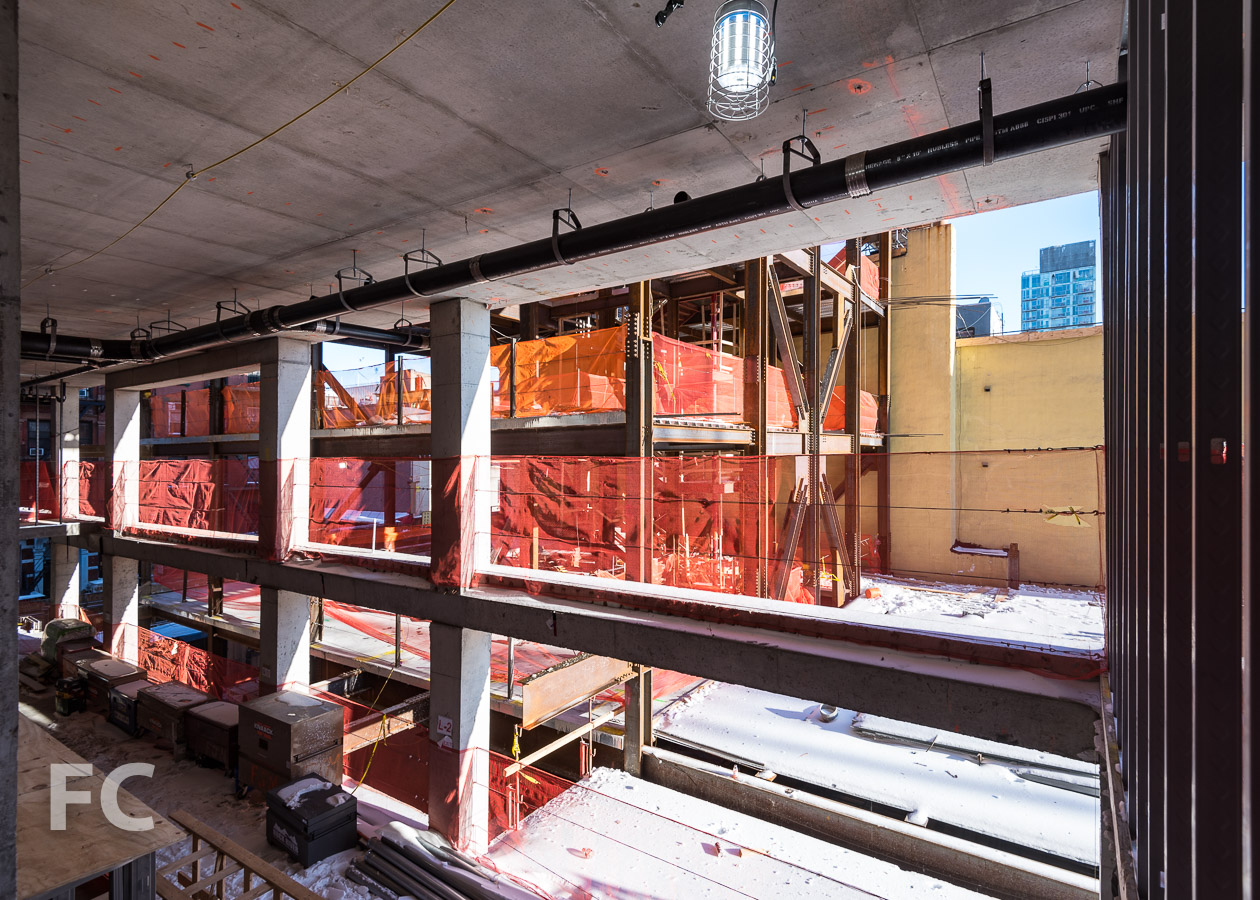View of the steel structure of the community facility space from the residential tower's concrete structure.