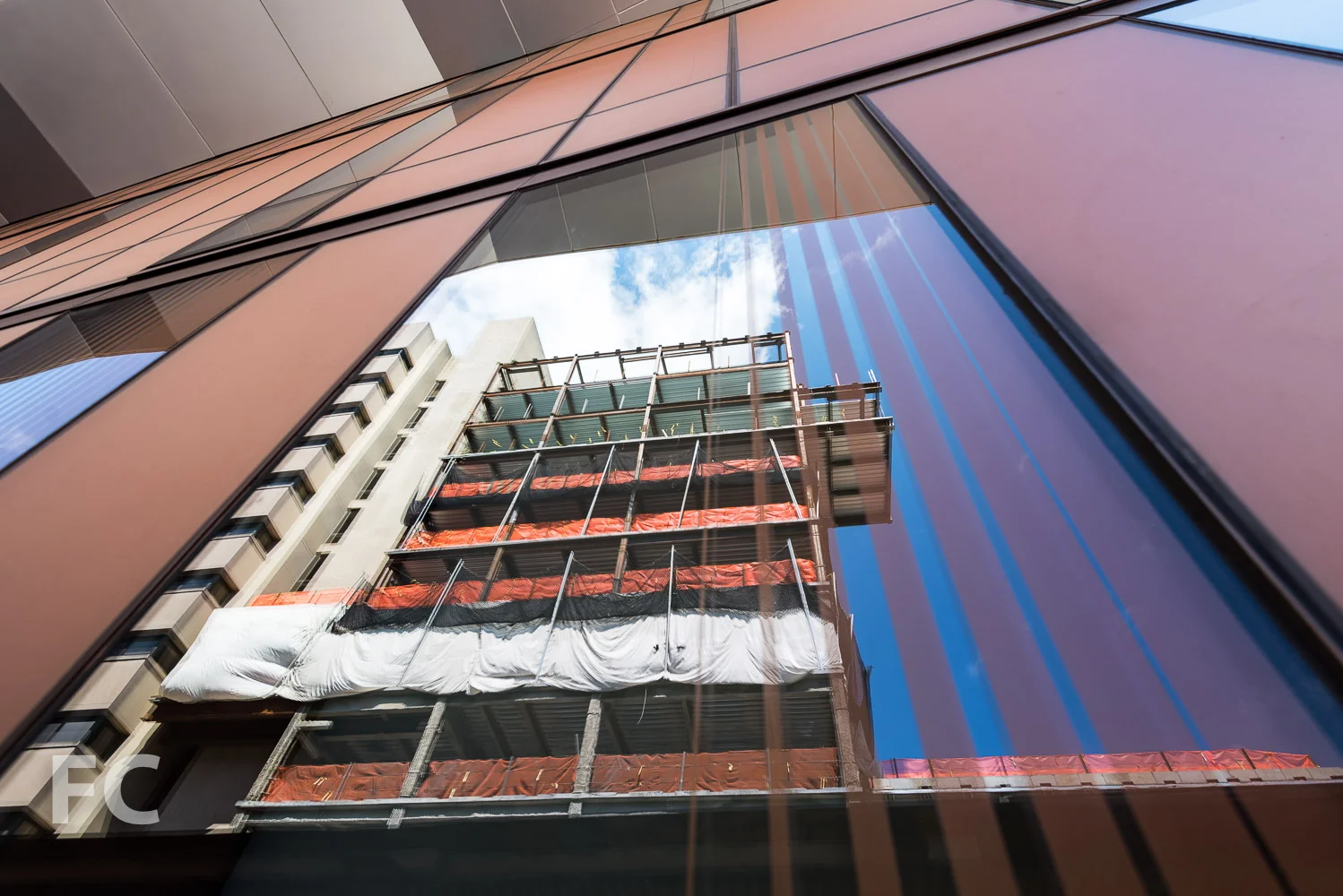 The Milstein Center reflected in the fritted glass façade of The Diana Center.
