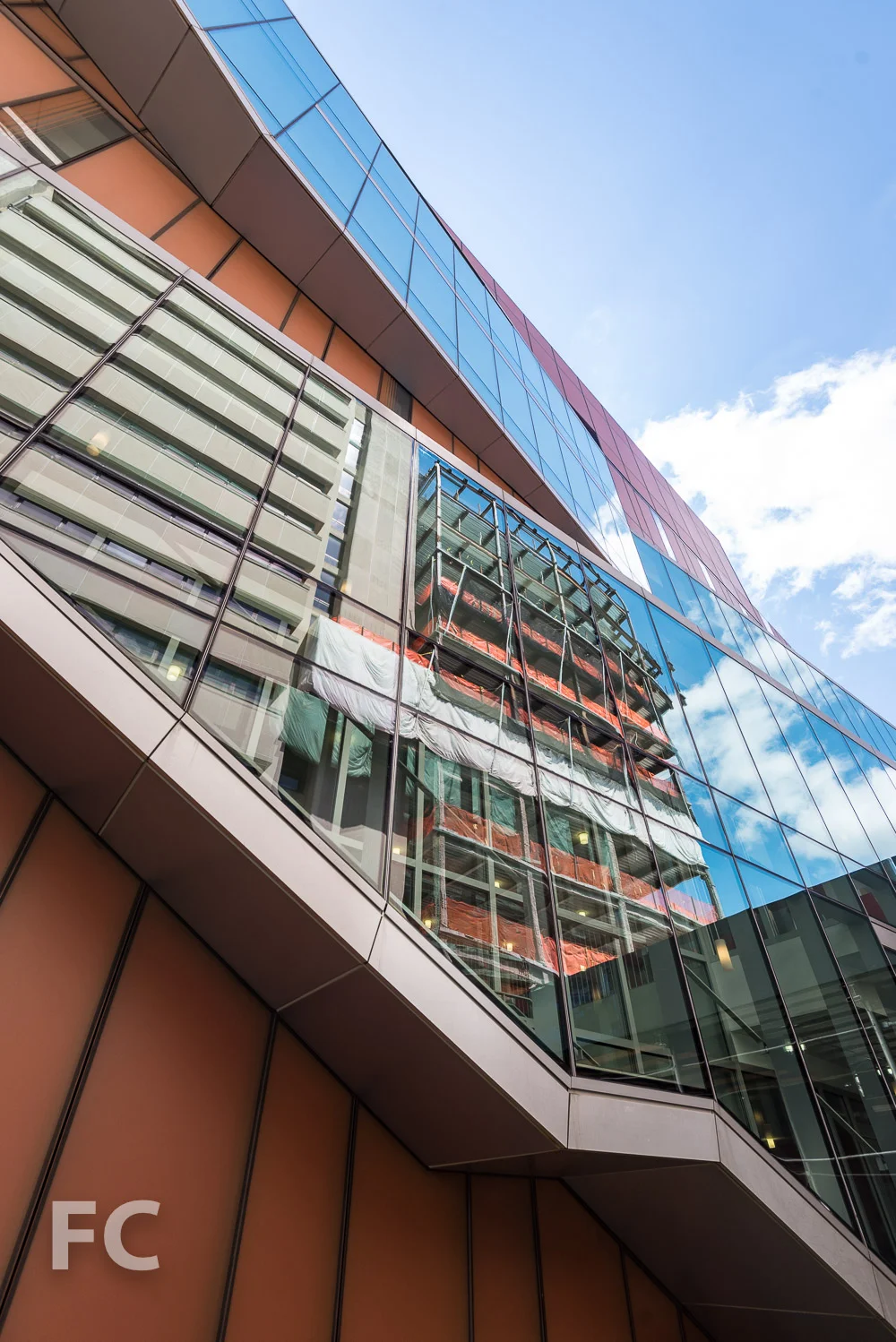 The Milstein Center reflected in the fritted glass façade of The Diana Center.