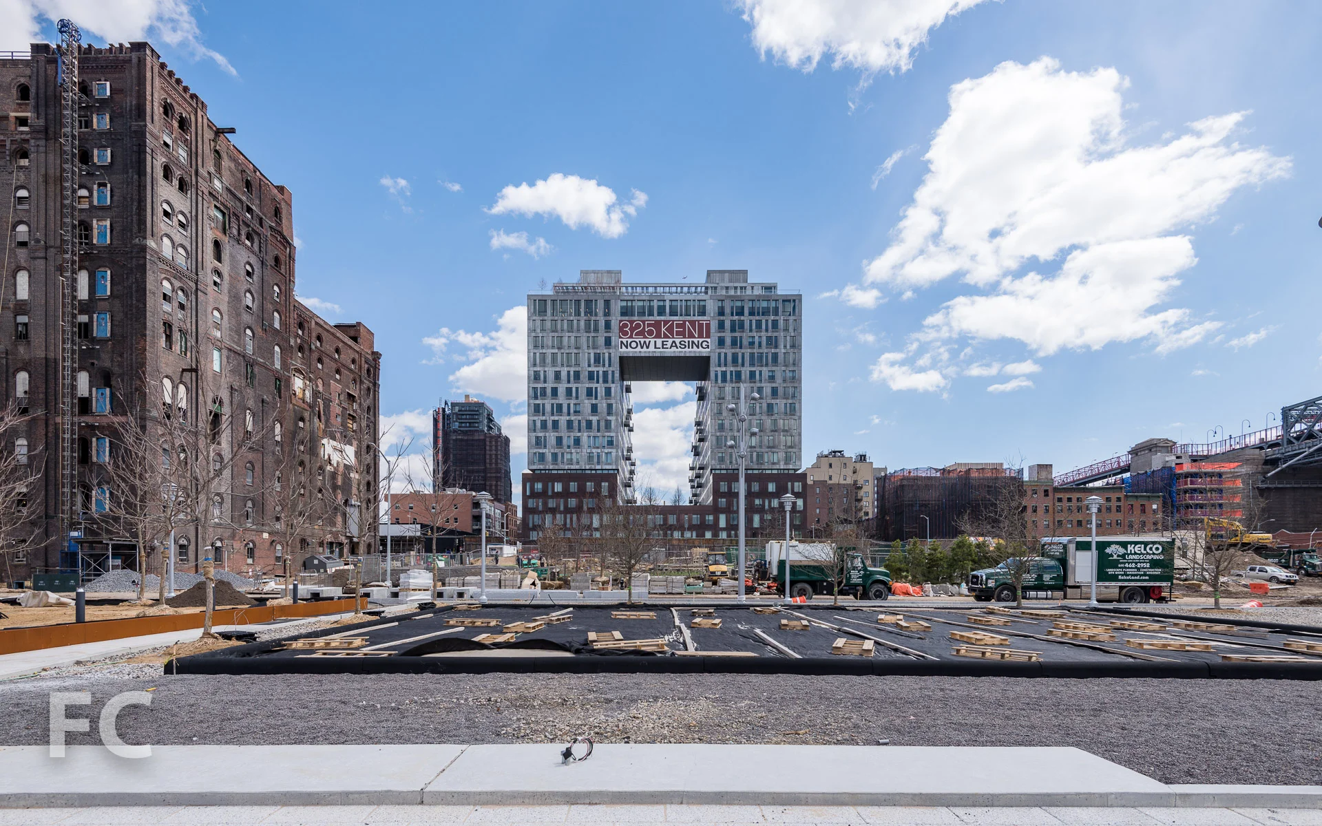 325 Kent Avenue (background) and the future volleyball court (foreground) from the active recreation area of the park