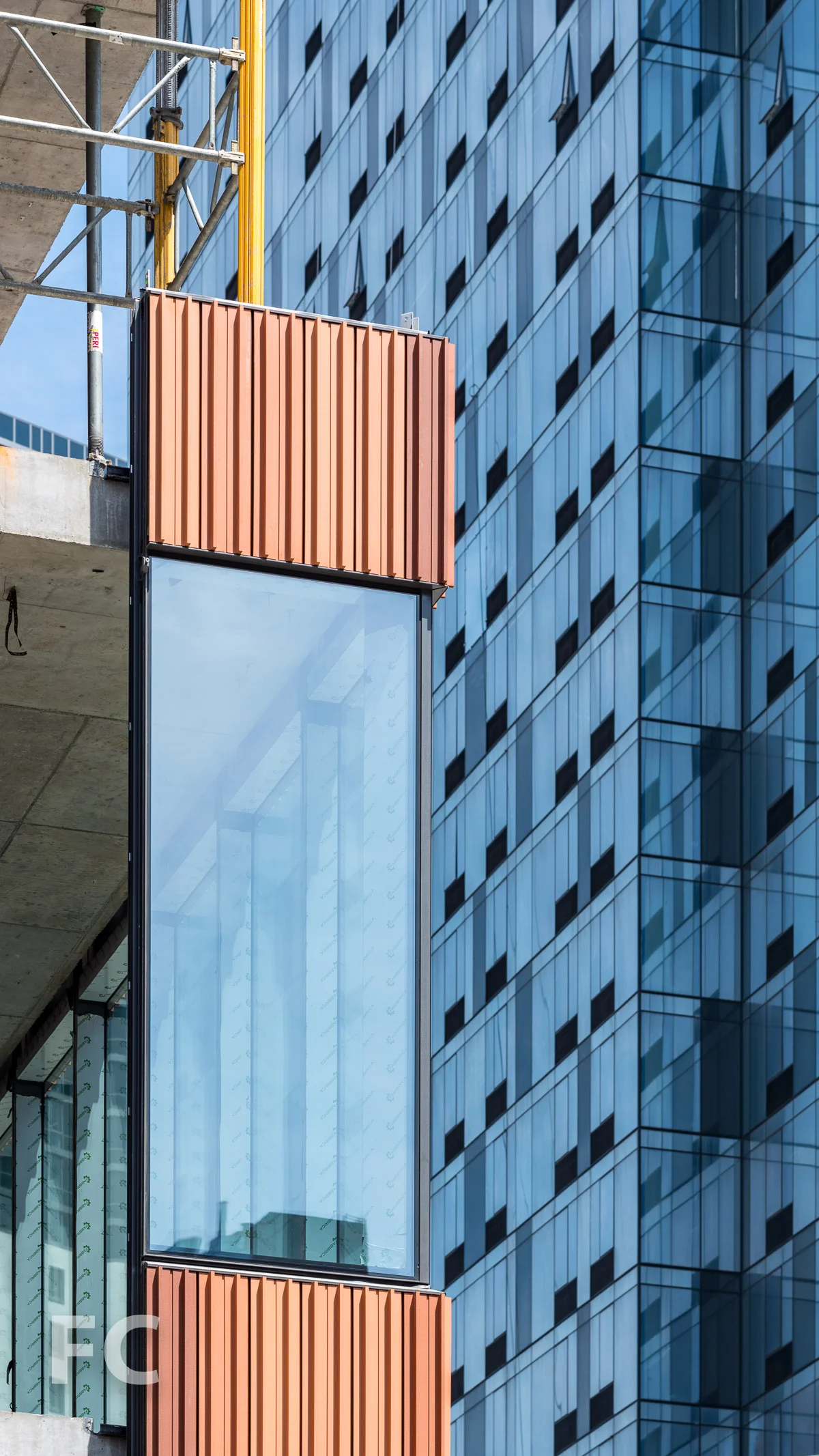 Close-up of the terracotta and glass curtain wall panels.