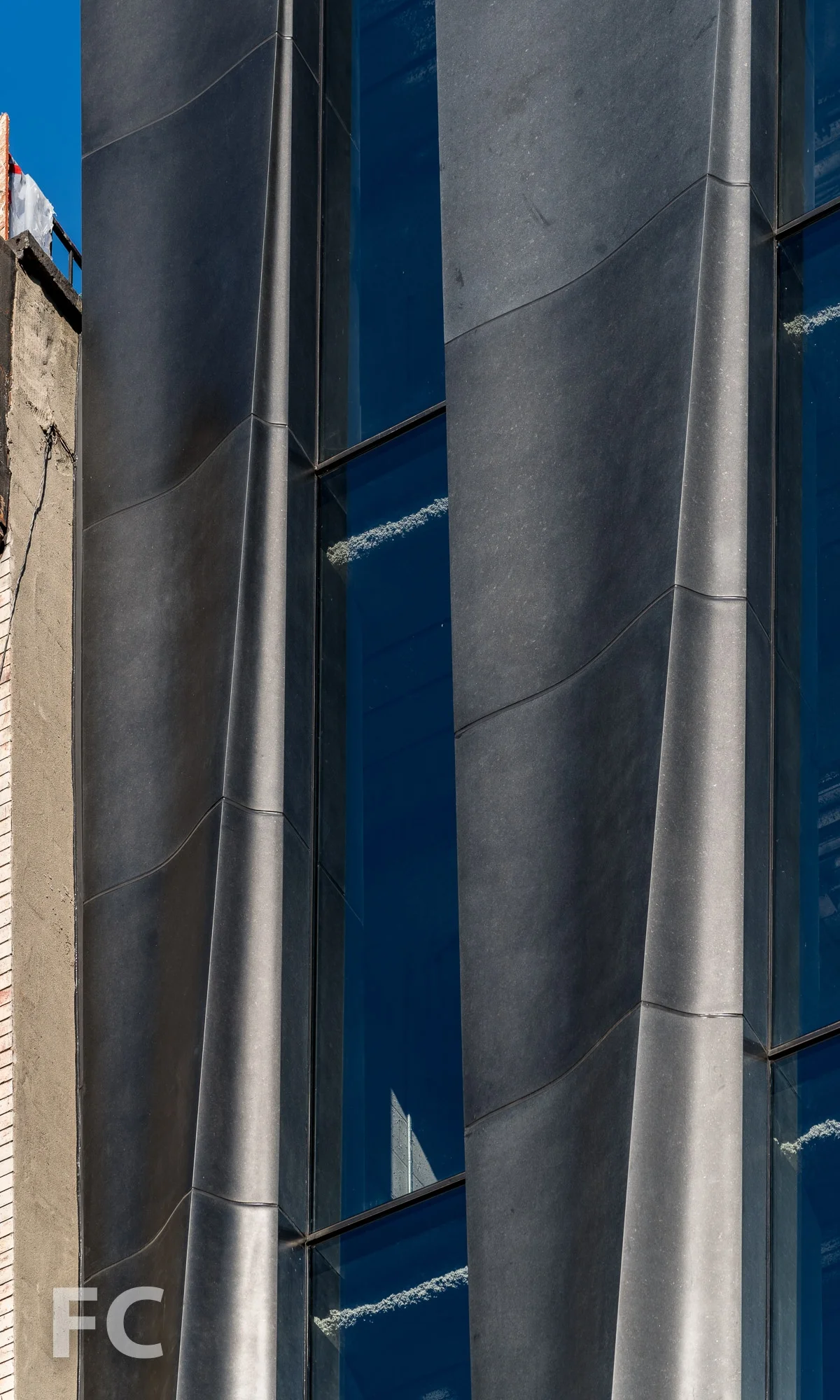 Close-up of the CNC milled stone and glass facade on Mott Street.