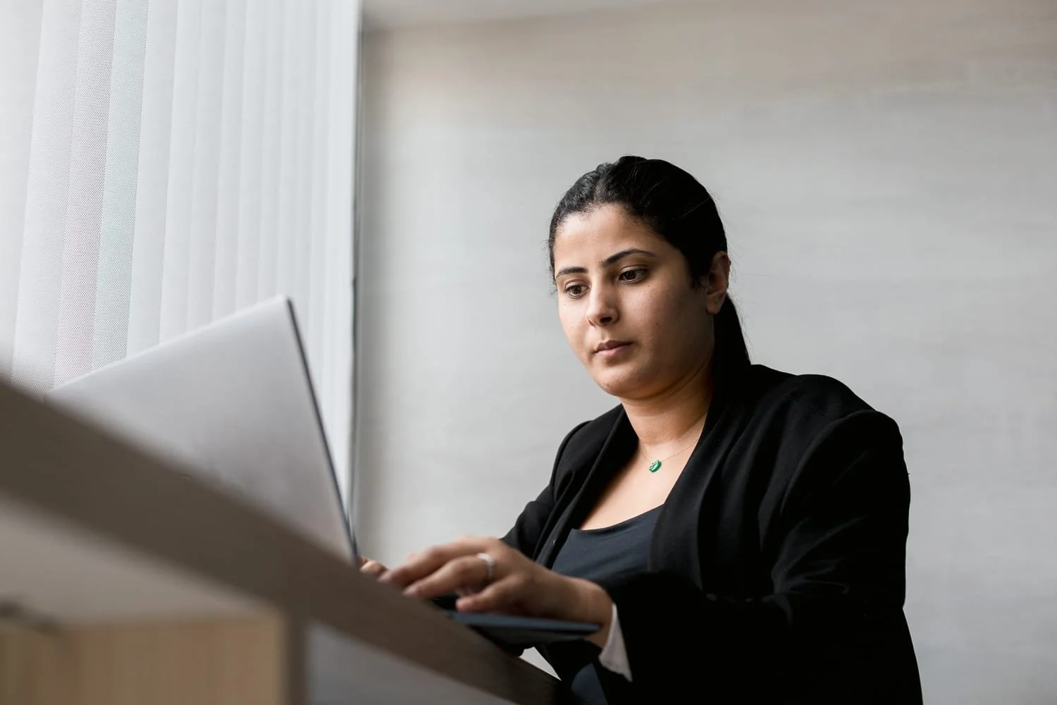 Collaboratrice concentrée sur son ordinateur dans un bureau
