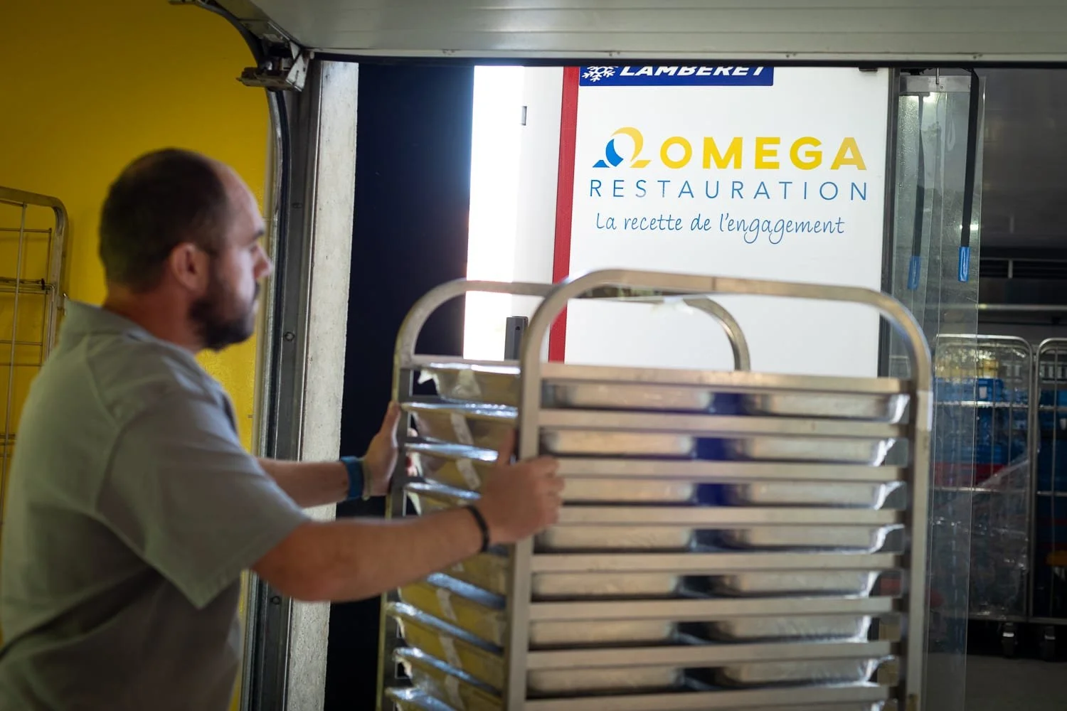 Logo Oméga restauration sur un camion de livraison dans un établissement client.