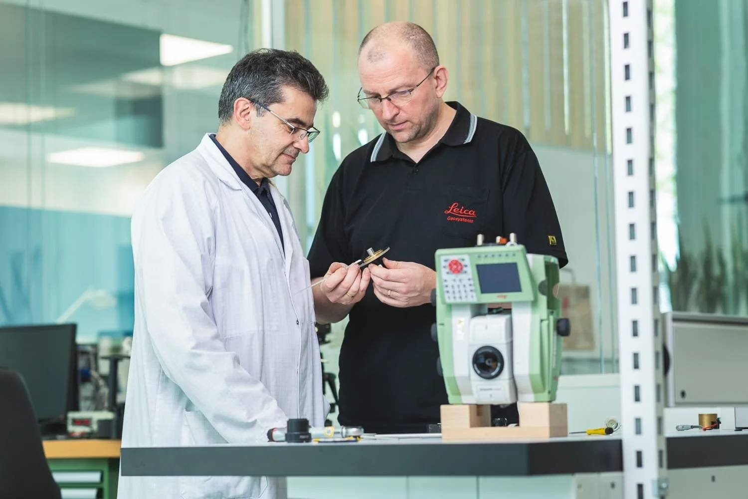 Techniciens en cours d'analyse  sur un équipement de mesure Leica Geosystem