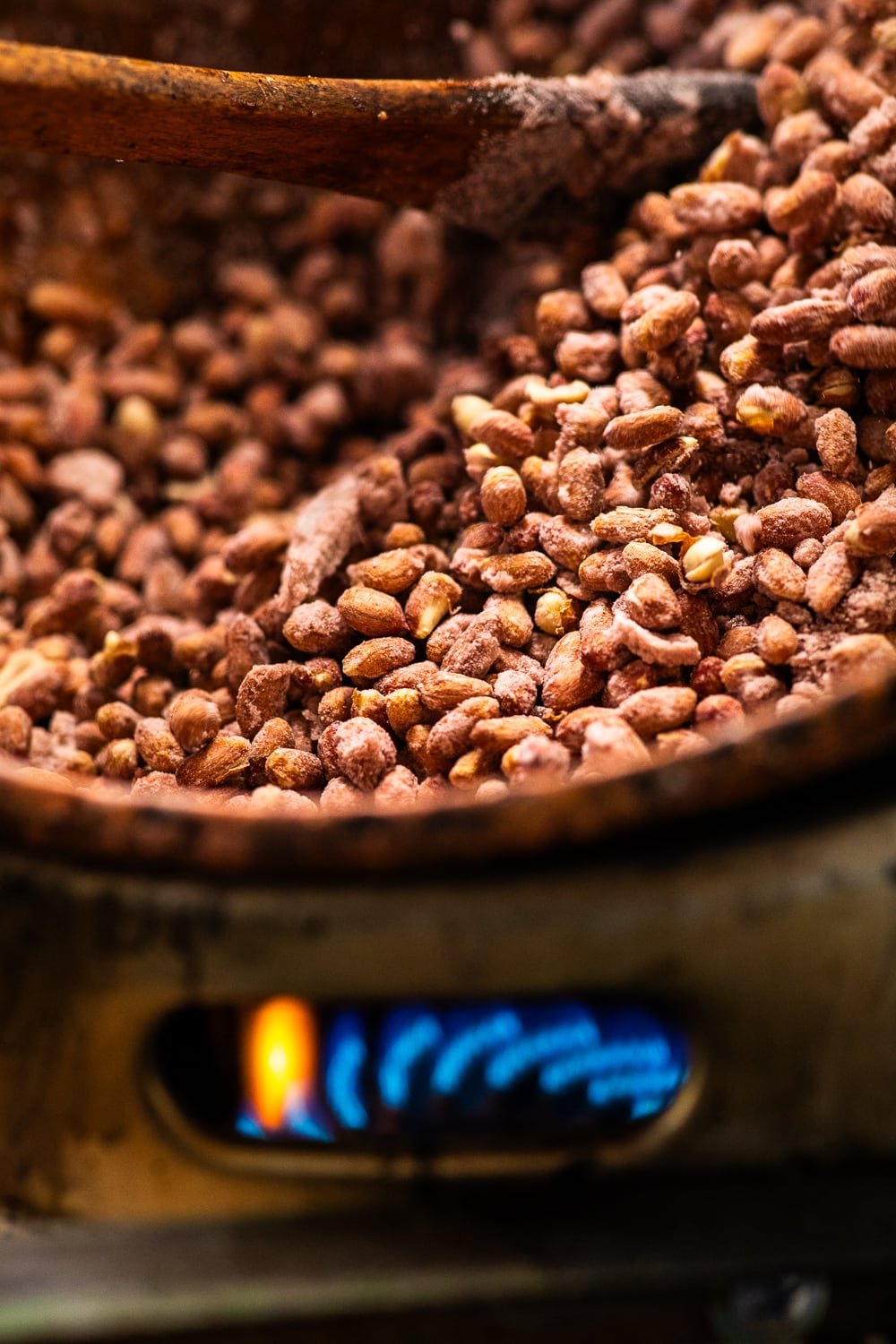 Gros plan sur les pralines en train de cuire dans un chaudron au-dessus du feu.