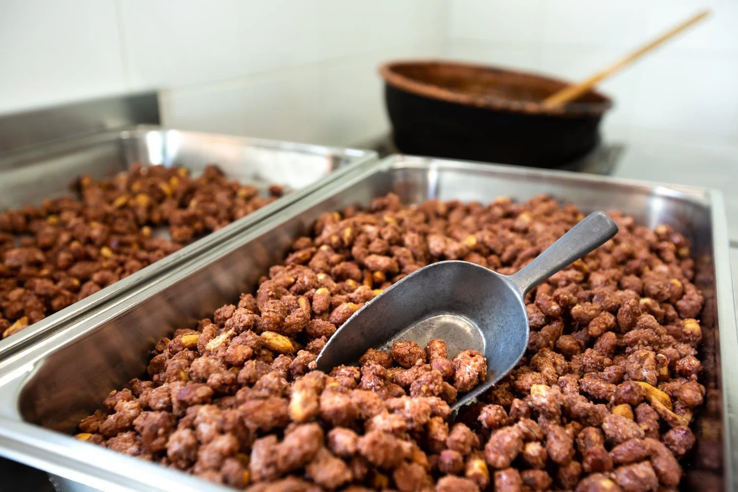 Gros plan sur les pralines disposées dans des plateaux avec pelle en métal.