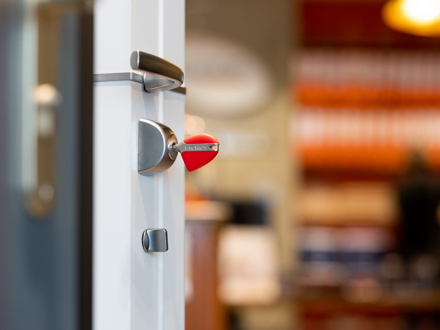 Reportage photo corporate, détail d’une clé dans une serrure de porte sécurisée en boutique.