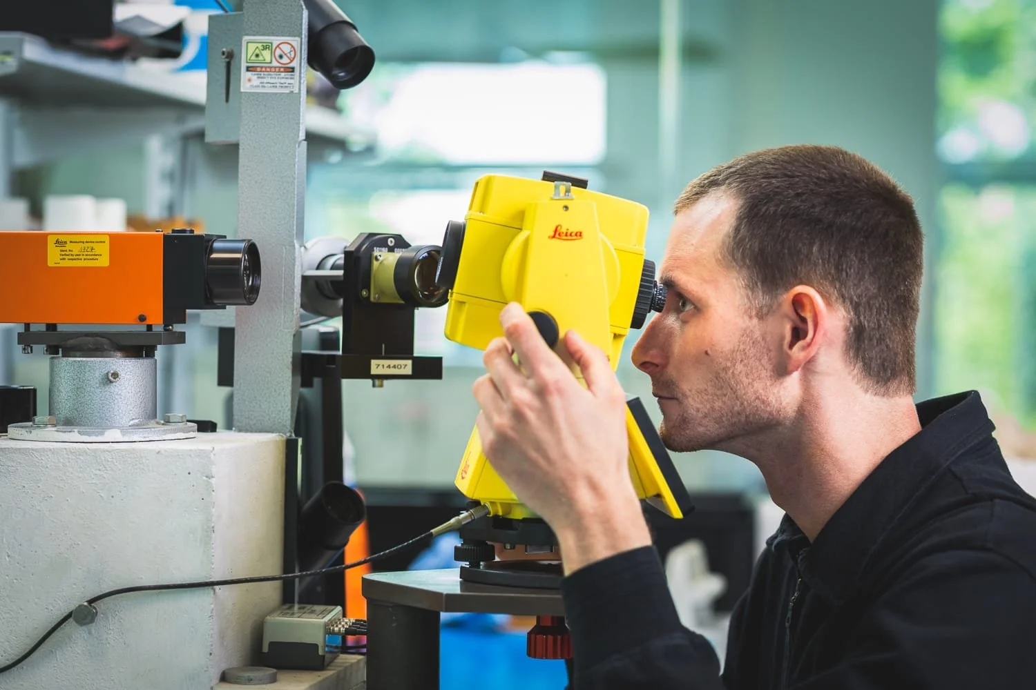 Photographe industriel – technicien vérifiant un instrument de mesure Leica en atelier