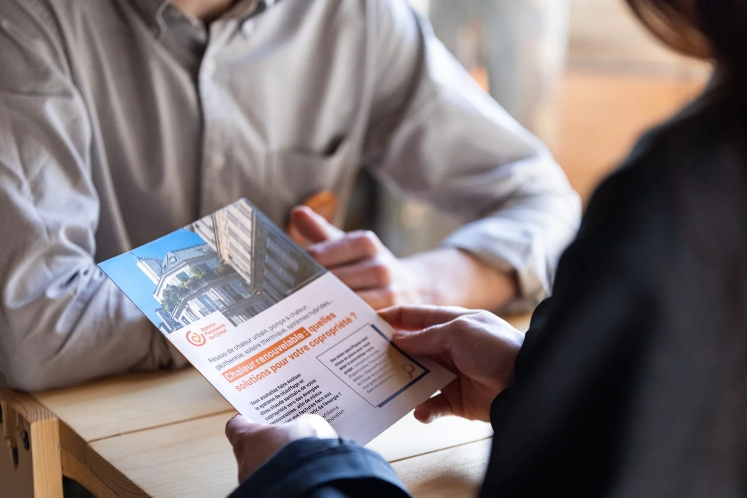 Visiteur consultant une documentation technique sur un stand lors d'un salon professionnel à Paris.